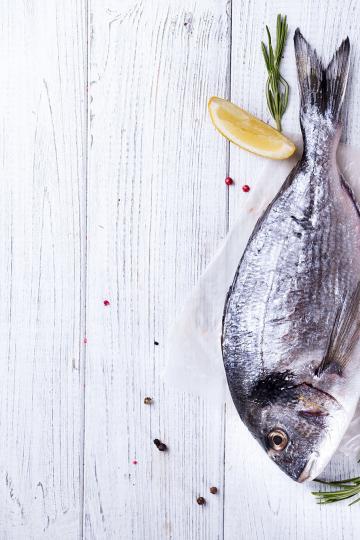 Zwei Doraden auf einer Tischplatte